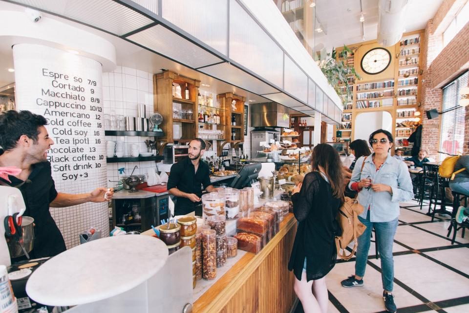 Customers being served at a busy coffee shop counter